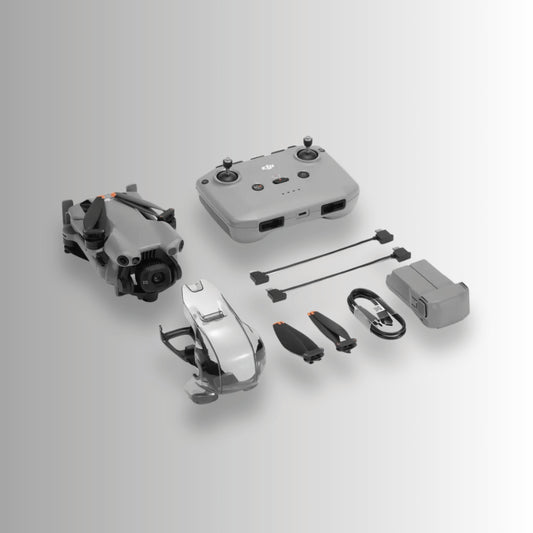DJI Mini 5 pro folded up beside the RC-N1 controller and other box contents on a plain grey/white gradient background