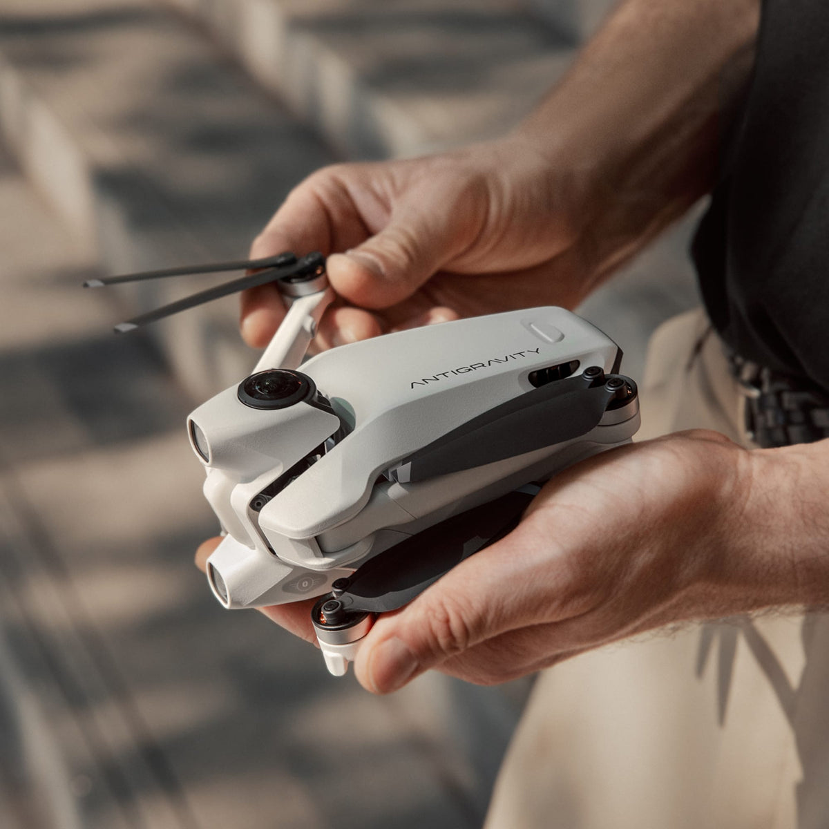 Antigravity A1 folded drone held in hands showing compact portable design for travel