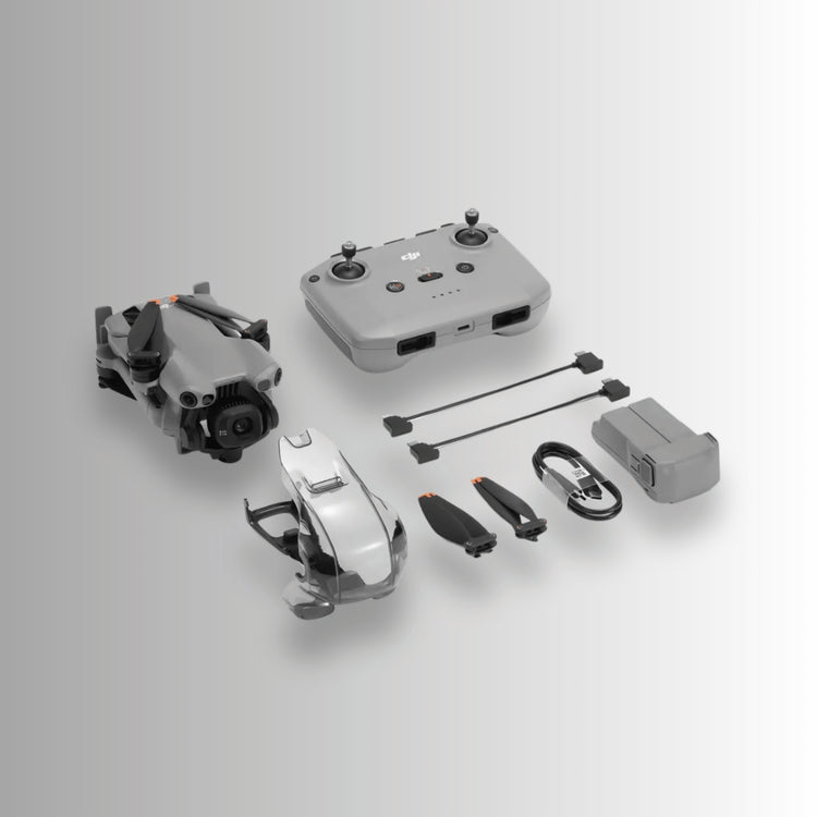DJI Mini 5 pro folded up beside the RC-N1 controller and other box contents on a plain grey/white gradient background