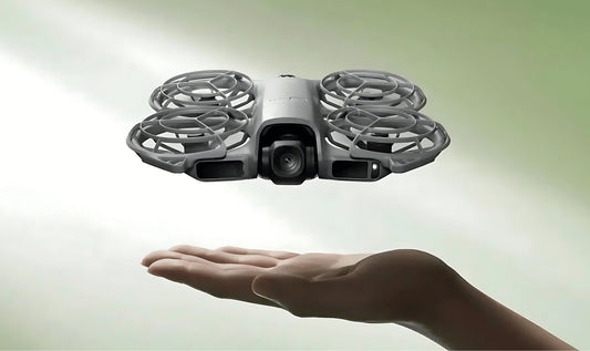 full camera shot of a hand in the air holiday a DJI Neo 2 drone flying above the palm of the hand with a green gradient background