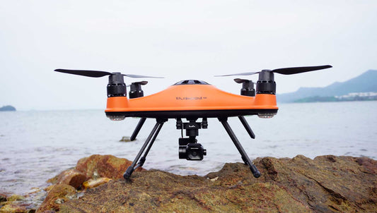 SwellPro SplashDrone 4+ (SD4+) sat on rock surface with sea in the background