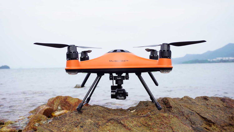 SwellPro SplashDrone 4+ (SD4+) sat on rock surface with sea in the background
