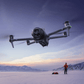 dji mavic 4 pro Drone flying over a snowy landscape with mountains in the background