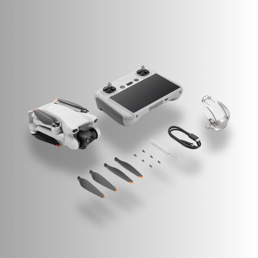 DJI Mini 3 drone with remote controller and accessories laid out on a gradient background