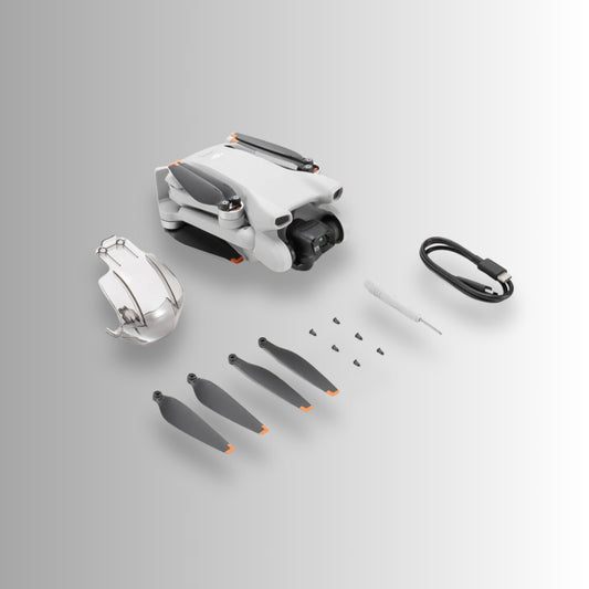DJI Mini 3 drone and accessories including propellers and tools, designed for aerial photography.