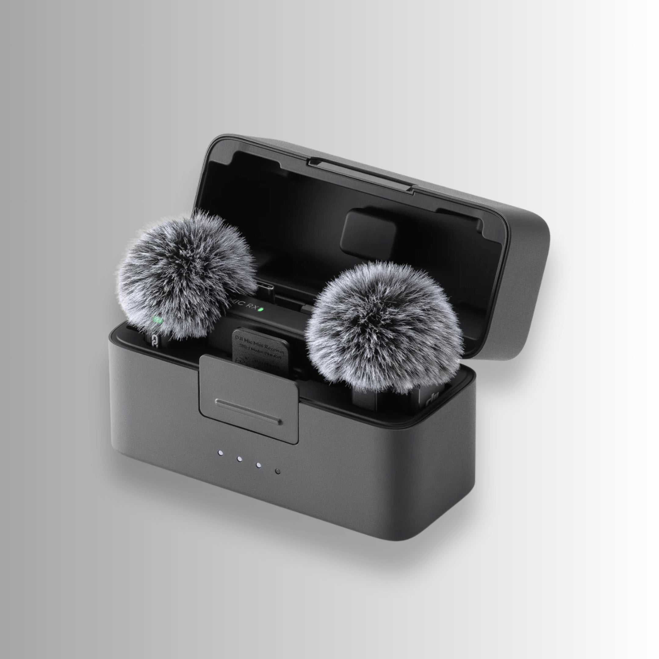 DJI Mic Mini transmitters with furry windshields placed in charging case for outdoor audio recording